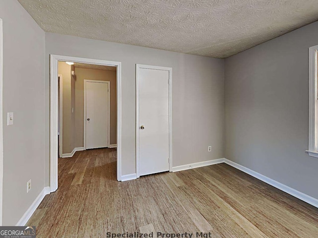 19 Hannon Way, Cartersville, GA 30120 - unfurnished bedroom featuring wood finished floors, baseboards, and a textured ceiling