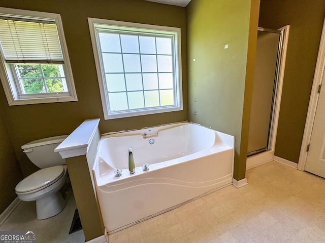 bathroom featuring a stall shower, a garden tub, toilet, and tile patterned floors