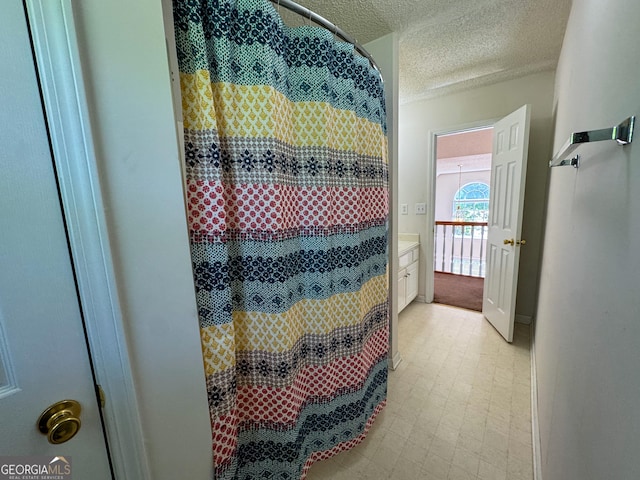 bathroom featuring a textured ceiling, tile patterned floors, and curtained shower