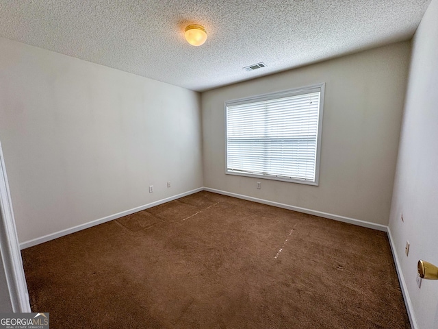unfurnished room featuring carpet floors, a textured ceiling, and baseboards
