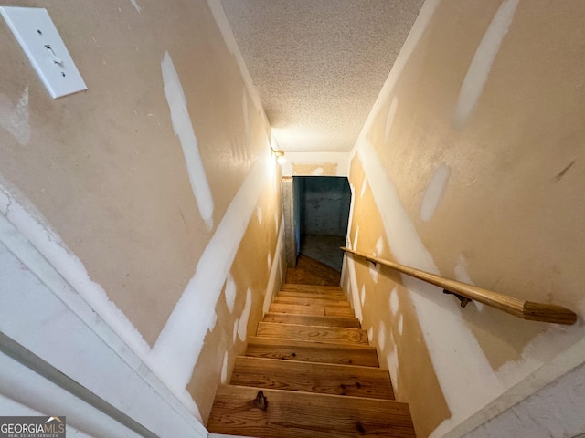 stairway with a textured ceiling