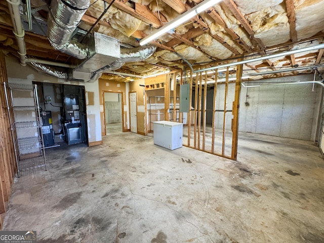 unfinished below grade area featuring electric panel and fridge