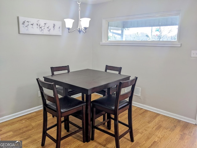 67 Sprayberry Rd, Newnan, GA 30263 - dining area with a chandelier, light wood-style flooring, and baseboards