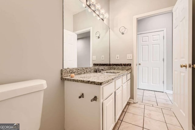bathroom featuring toilet, vanity, and tile patterned floors