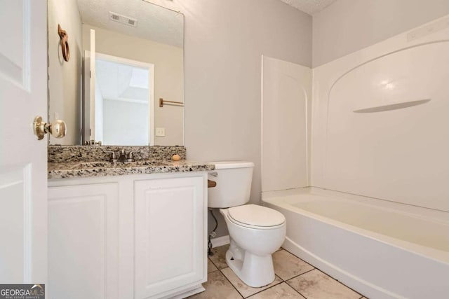 bathroom with tile patterned floors, toilet, vanity, tub / shower combination, and a textured ceiling