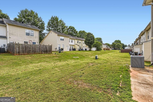 view of yard featuring central air condition unit, a residential view, and fence