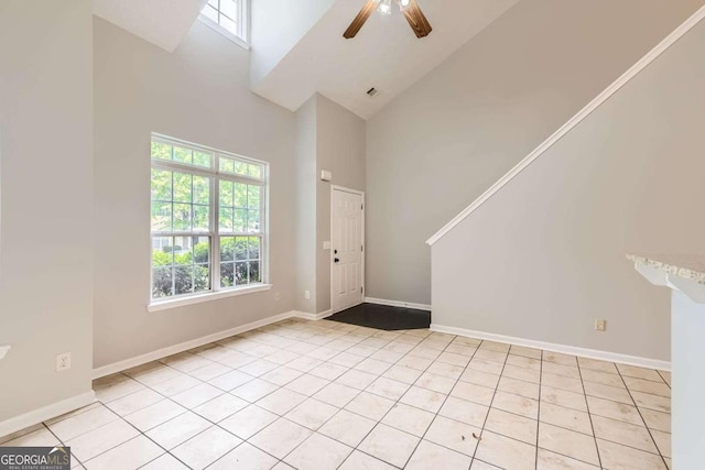 unfurnished room featuring high vaulted ceiling, light tile patterned flooring, a ceiling fan, and baseboards