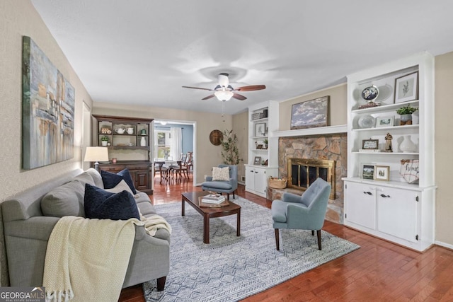 1870 Shoreline Trce, Grayson, GA 30017 - living room with a stone fireplace, ceiling fan, wood finished floors, baseboards, and built in shelves