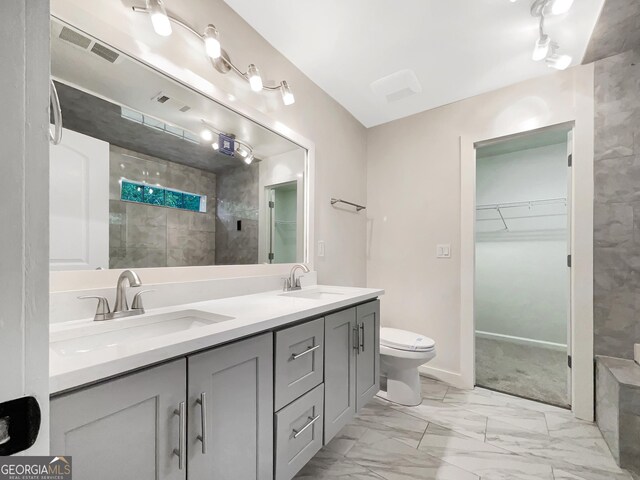 617 Kyles Cir, Hiram, GA 30141 - bathroom featuring tiled shower, marble finish floors, a walk in closet, double vanity, and toilet