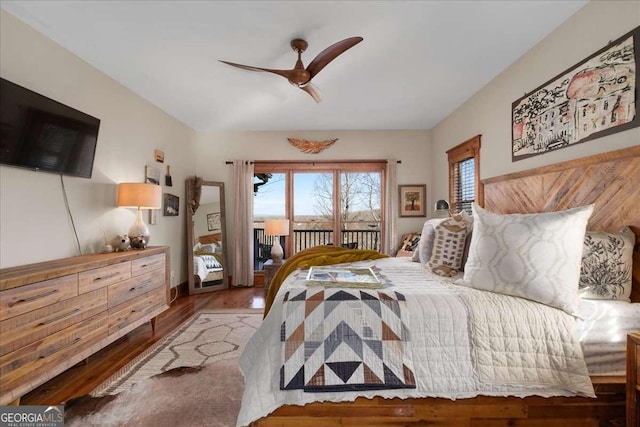 bedroom featuring access to exterior, wood finished floors, and a ceiling fan