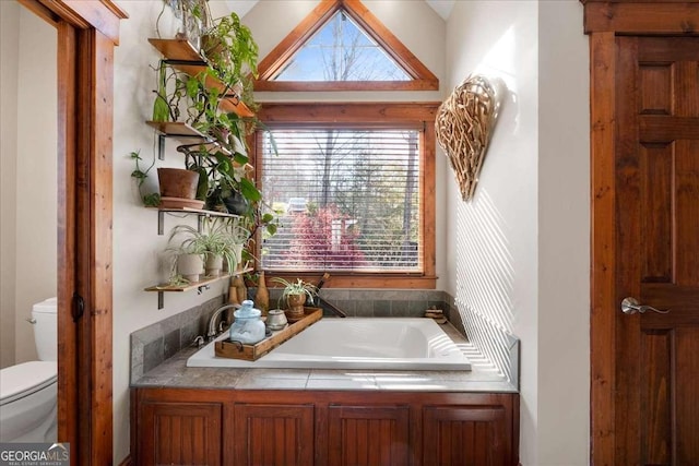 bathroom with toilet and a garden tub