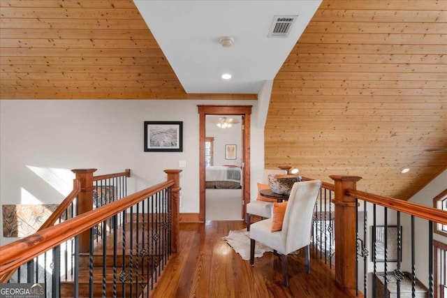 corridor featuring recessed lighting, wood finished floors, baseboards, and an upstairs landing