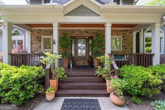 property entrance featuring covered porch and stone siding