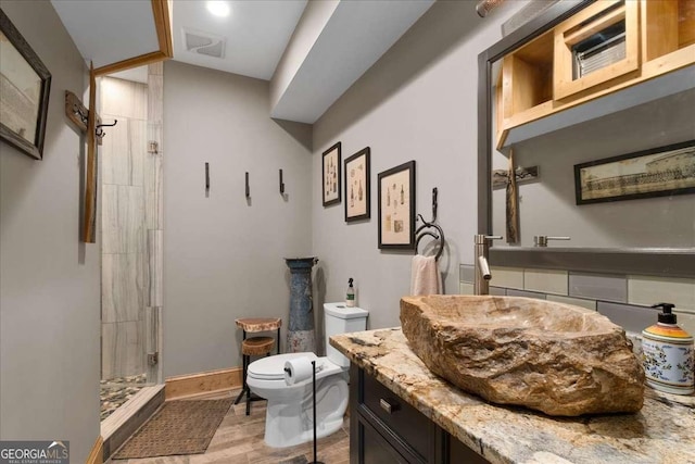 full bathroom featuring a shower stall, wood finished floors, toilet, vanity, and lofted ceiling