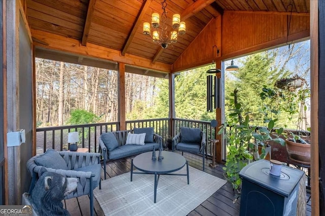 sunroom / solarium with lofted ceiling, an outdoor living space, and a chandelier