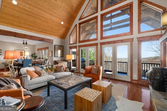 living area with hardwood / wood-style floors, healthy amount of natural light, high vaulted ceiling, and wood ceiling