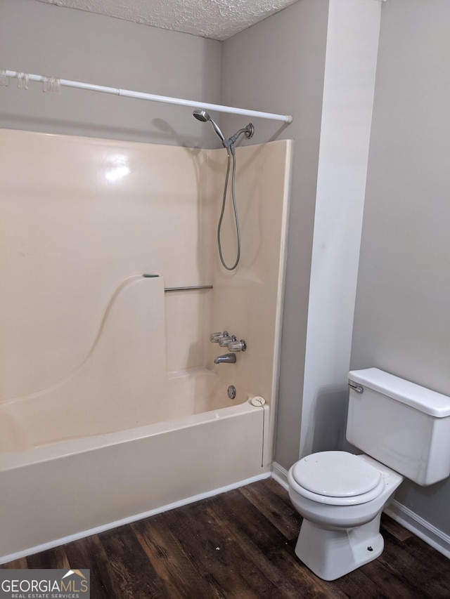 135 Beverly Park Ct, Newnan, GA 30263 - bathroom featuring wood finished floors, toilet,  shower combination, baseboards, and a textured ceiling