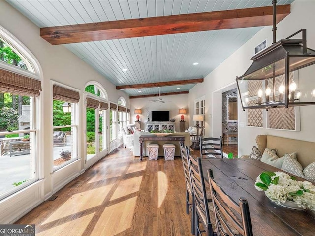 dining area featuring beam ceiling, wood finished floors, plenty of natural light, a chandelier, and wooden ceiling