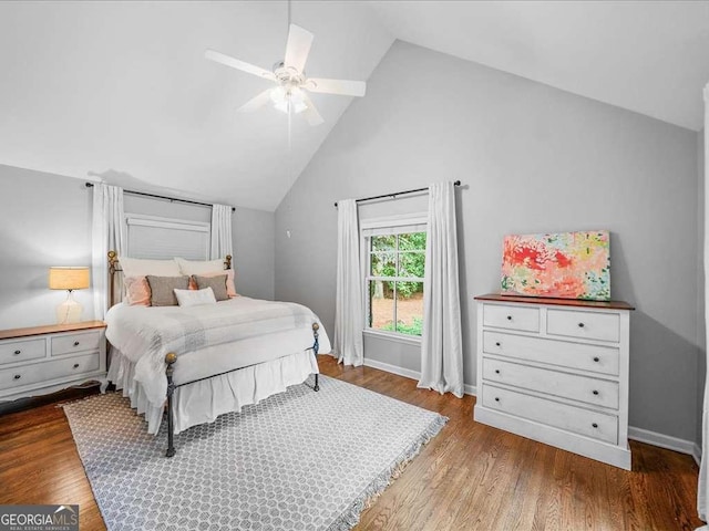 bedroom with wood finished floors, ceiling fan, baseboards, and high vaulted ceiling