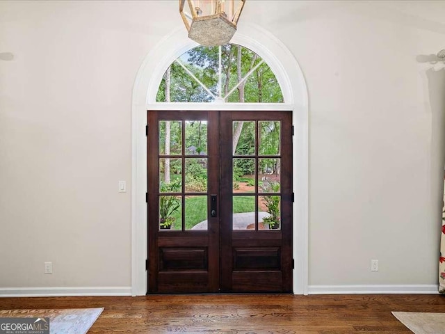 foyer entrance with french doors, baseboards, and wood finished floors