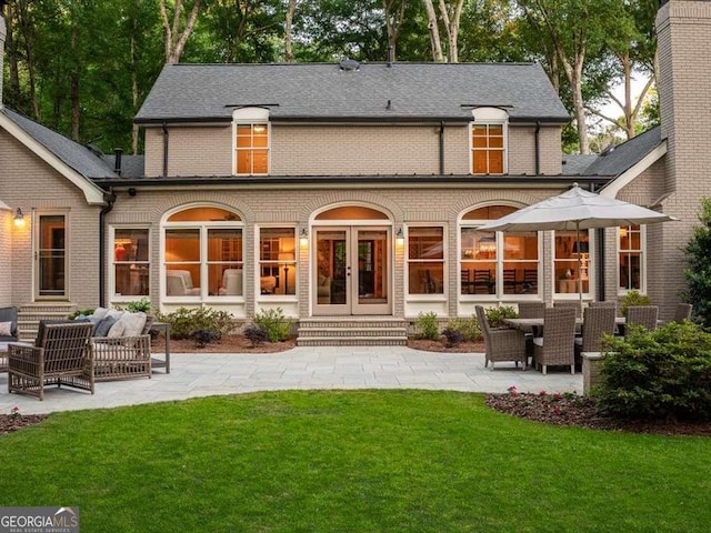 back of property featuring a patio, french doors, a yard, and an outdoor hangout area