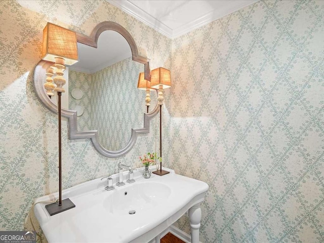 bathroom with crown molding and wallpapered walls