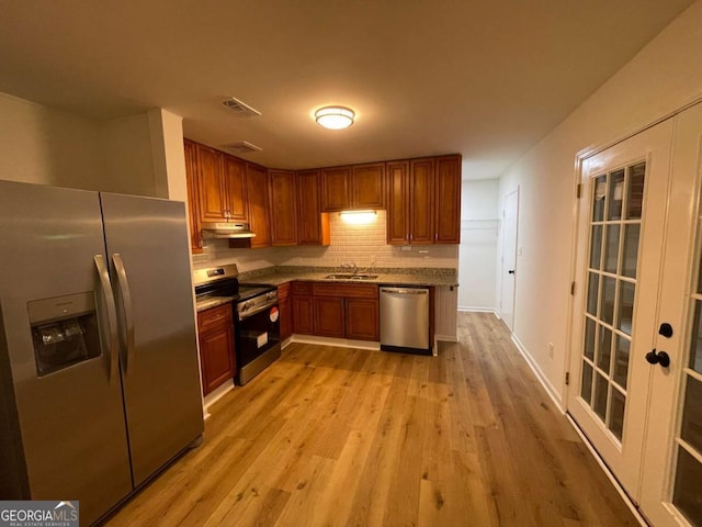 6927 Eunice Dr, Riverdale, GA 30274 - kitchen with stainless steel appliances, under cabinet range hood, light wood-style flooring, decorative backsplash, and a sink