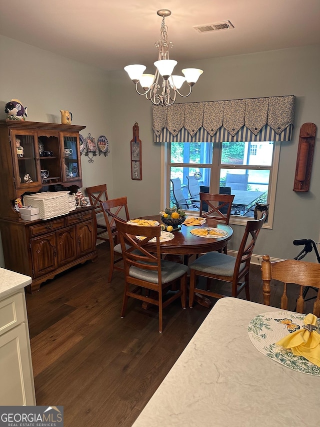 dining area featuring dark wood-style floors and a chandelier