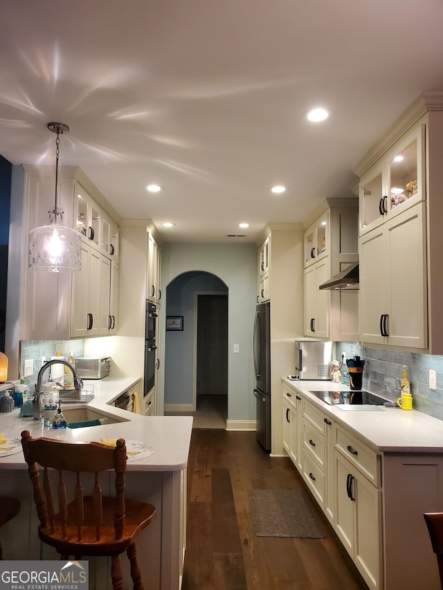 106 Hamway Ln, Winder, GA 30680 - kitchen with arched walkways, black appliances, a sink, light countertops, and backsplash