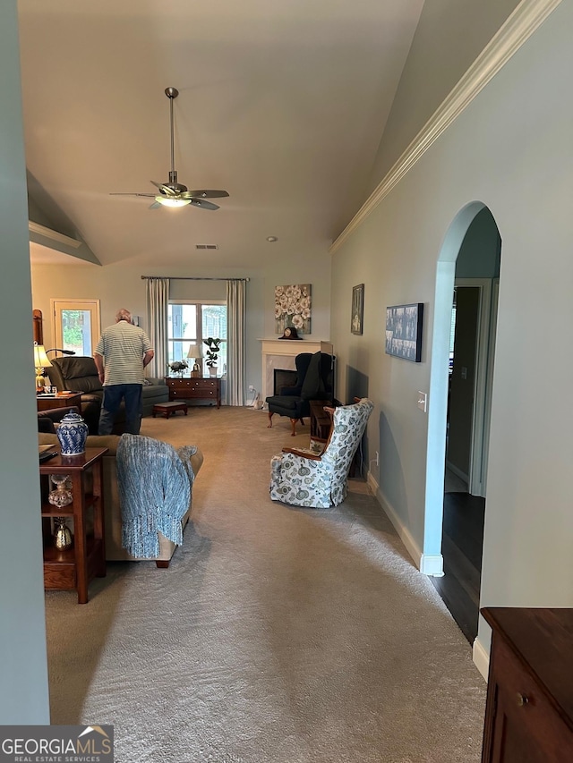 living area with arched walkways, a ceiling fan, carpet, high vaulted ceiling, and a fireplace