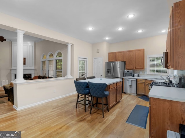 361 Brackin Trce, Grayson, GA 30017 - kitchen with ornate columns, stainless steel appliances, a breakfast bar, brown cabinets, and recessed lighting