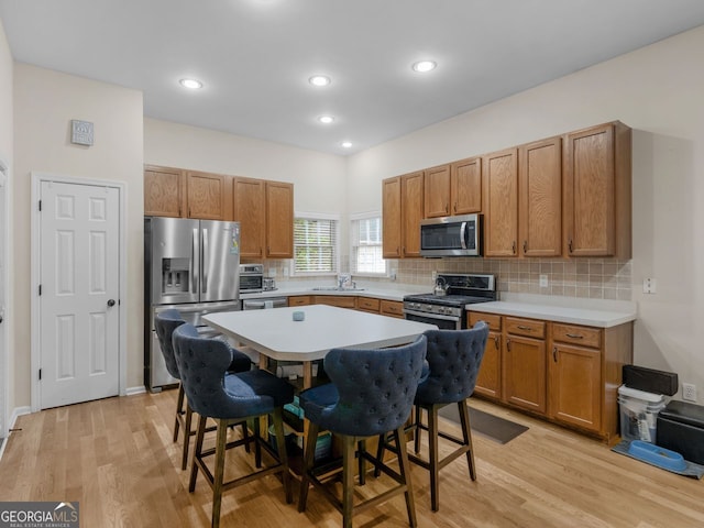 361 Brackin Trce, Grayson, GA 30017 - kitchen with appliances with stainless steel finishes, a sink, a kitchen breakfast bar, light wood-type flooring, and recessed lighting