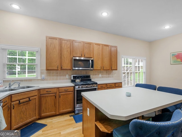 361 Brackin Trce, Grayson, GA 30017 - kitchen with appliances with stainless steel finishes, a breakfast bar, open shelves, light wood-style flooring, and plenty of natural light