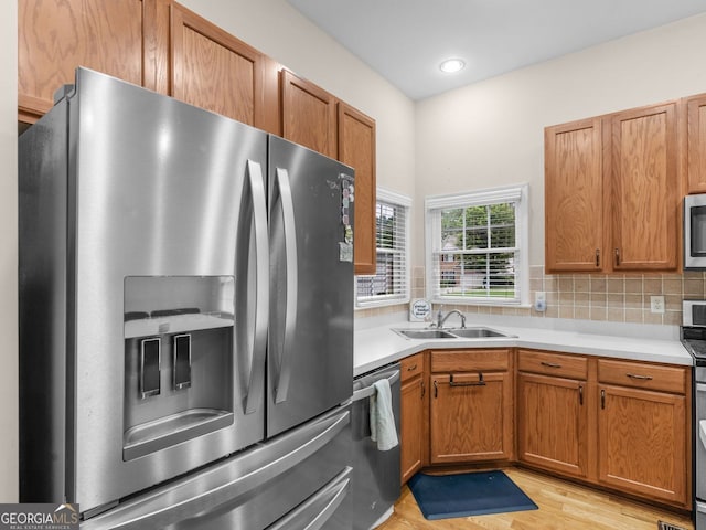 361 Brackin Trce, Grayson, GA 30017 - kitchen with stainless steel appliances, a sink, light countertops, light wood-type flooring, and backsplash