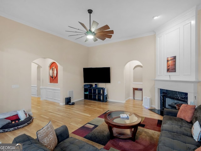 361 Brackin Trce, Grayson, GA 30017 - living area with arched walkways, a ceiling fan, light wood-type flooring, ornamental molding, and a fireplace