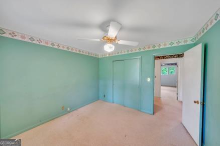 111 Roberson St, Dublin, GA 31021 - unfurnished bedroom featuring a closet, light carpet, and ceiling fan