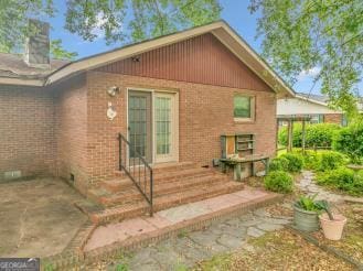 111 Roberson St, Dublin, GA 31021 - view of property exterior with brick siding, a patio, and a chimney