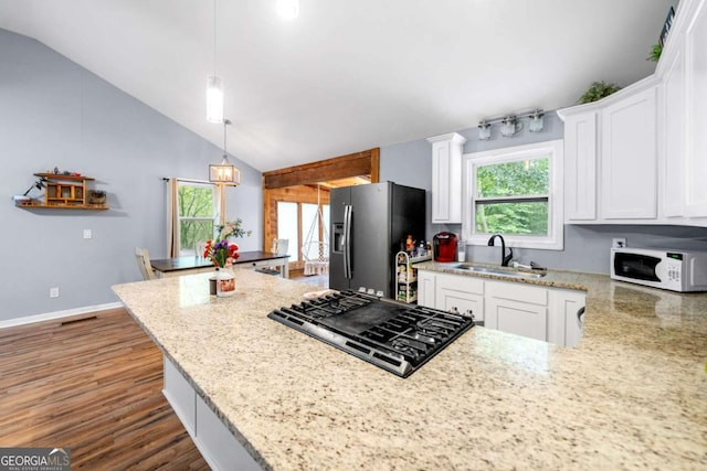115 S Meadowcliff Cir, Carrollton, GA 30116 - kitchen with white microwave, a sink, stainless steel refrigerator with ice dispenser, black gas cooktop, and white cabinets