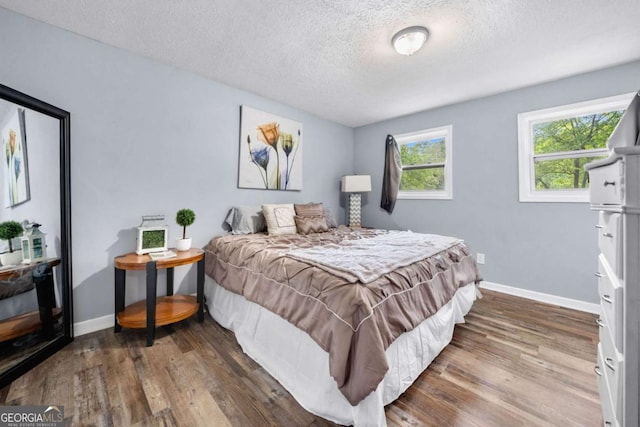 115 S Meadowcliff Cir, Carrollton, GA 30116 - bedroom featuring a textured ceiling and wood finished floors