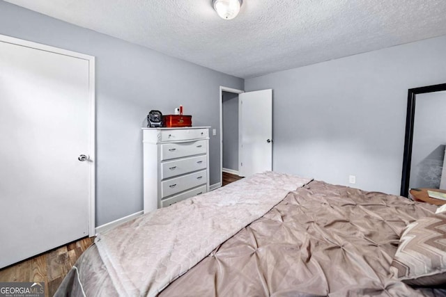 115 S Meadowcliff Cir, Carrollton, GA 30116 - bedroom with wood finished floors, a textured ceiling, and baseboards