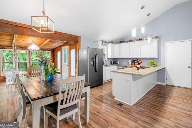 115 S Meadowcliff Cir, Carrollton, GA 30116 - kitchen featuring stainless steel appliances, a peninsula, light wood-type flooring, white cabinets, and vaulted ceiling