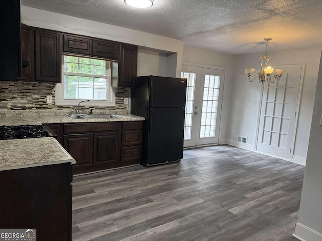 5460 Huron Dr, Morrow, GA 30260 - kitchen with freestanding refrigerator, a sink, a textured ceiling, a chandelier, and backsplash