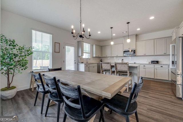 dining space with dark wood finished floors, a chandelier, recessed lighting, and baseboards