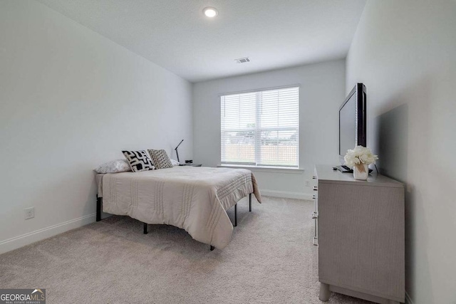bedroom with baseboards and light colored carpet