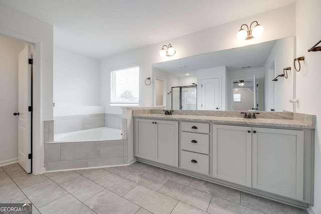 bathroom featuring double vanity, a bath, tile patterned flooring, and a stall shower