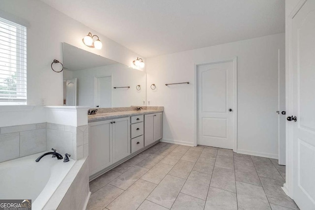 full bath with double vanity, a bath, tile patterned flooring, and baseboards