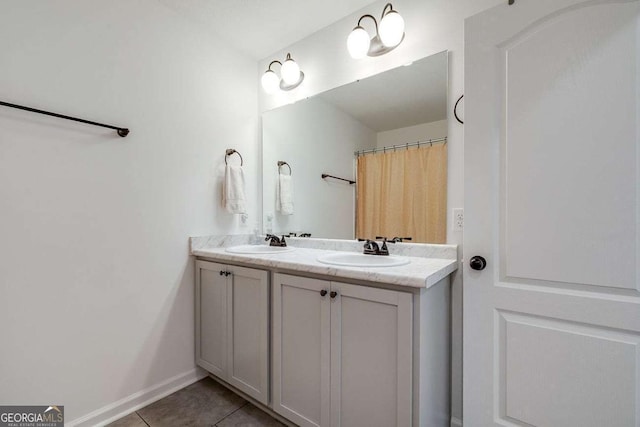 bathroom with tile patterned floors, double vanity, and baseboards