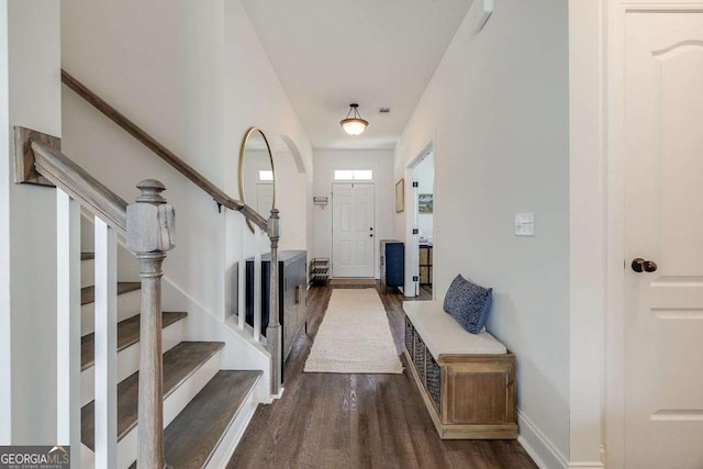 foyer with dark wood-type flooring, stairway, and baseboards