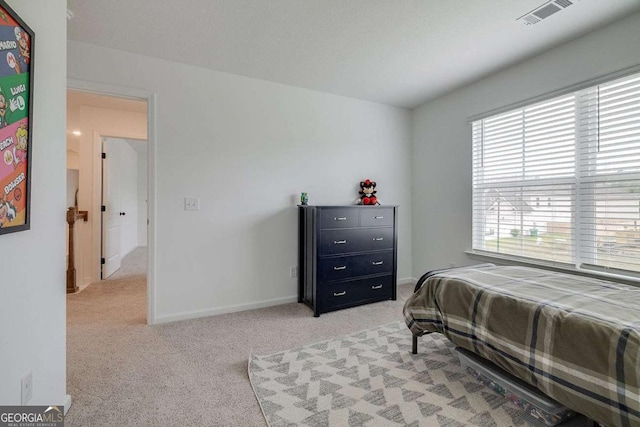 bedroom featuring light carpet and baseboards