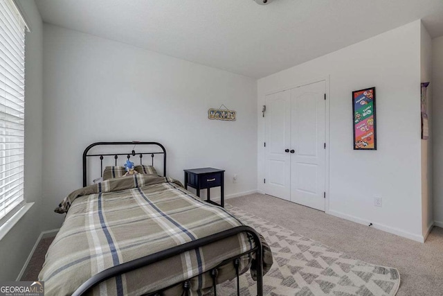bedroom with carpet flooring, baseboards, and a closet